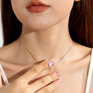 Gros plan d'un ras de cou invisible avec pendentif aurore boréale sur le cou du mannequin