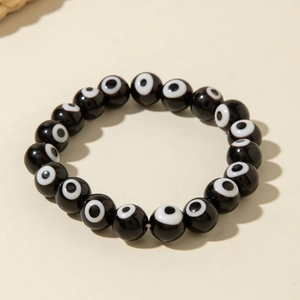 Macro detail of Bohemian evil eye stretch bracelet featuring polished black resin beads