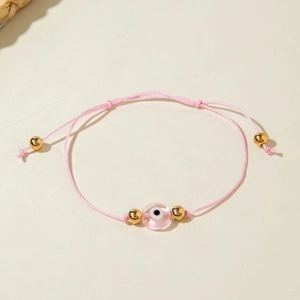 Pink bohemian evil eye cord bracelet with gold beads and adjustable slider knot