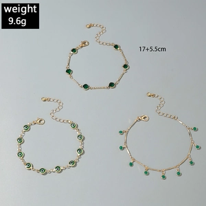 Three-piece gold-toned charm bracelet set with evil eye patterns and green gemstones