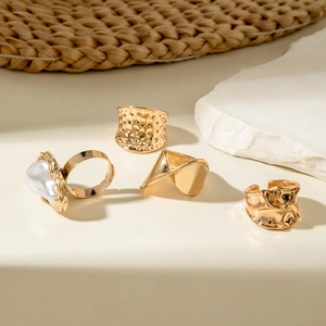 Golden irregular geometric rings set with baroque pearl in a minimalist boho style