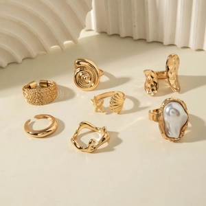 7-piece gold ring set featuring baroque pearl with seashell and starfish ocean motifs