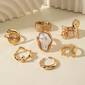 Detailed set of 7 gold baroque pearl rings with shell and starfish ocean theme