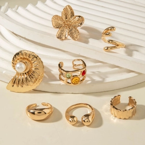 Detail of gold floral jewelry set with baroque pearls and colorful gemstones