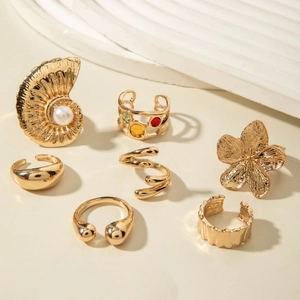 Detail shot of a 7-piece gold floral ring set featuring baroque pearls and colorful gems