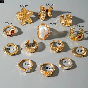 Detail shot of 11-piece gold ring set with baroque pearls and floral metal designs