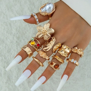 Detailed set of 14 gold rings featuring baroque pearls and colorful gemstone accents
