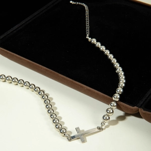 Detailed view of silver cross pearl necklace with round beads and adjustable chain