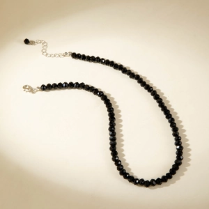 Close-up of black faceted beaded necklace with silver lobster clasp and extension chain