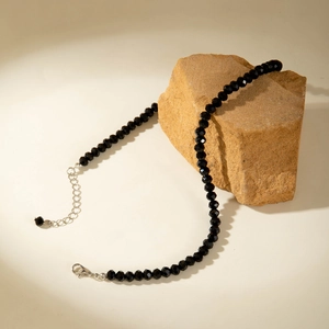 Detailed macro view of faceted black beaded necklace with silver adjustable chain extender
