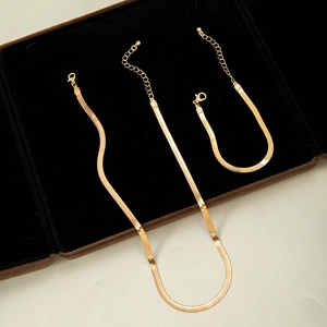 Golden flat snake bone necklace and bracelet set with lobster clasp in a jewelry box