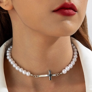 Minimalist pearl necklace with silver cross pendant shown on model neck profile