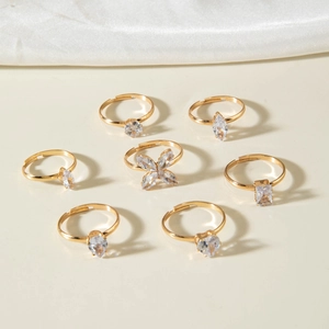 Lot de sept bagues dorées ajustables ornées de pierres en forme de goutte et zircons