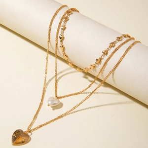 Gros plan du collier triple rang doré avec pendentifs cœurs et perles élégantes