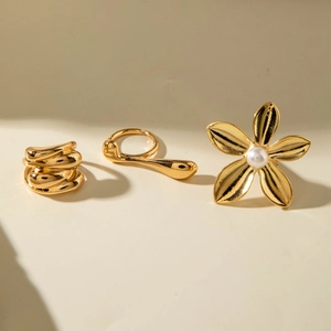 Three-piece gold flower and pearl ring set with layered metal wrap and irregular drop design