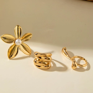 Detail of gold flower ring with pearl and irregular spiral bands in a jewelry set