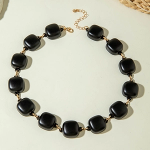 Detail of matte black acrylic beads with golden metal links and adjustable lobster clasp