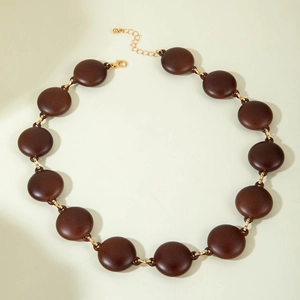 Macro detail of retro brown acrylic bead necklace with elegant gold metal ring links
