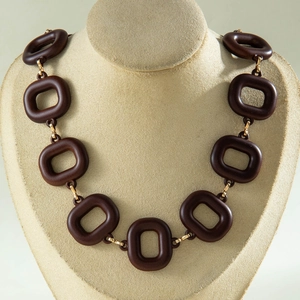Detail showing vintage chunky brown acrylic links with gold metal connectors on a neck model