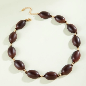 Detail of dark brown oval acrylic beads with gold chain connectors and lobster clasp