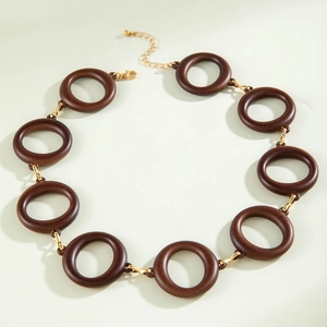 Detailed macro view of dark brown acrylic rings linked with gold metal chains