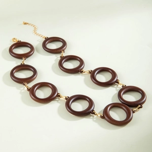 Detail of interlocking brown acrylic rings and gold metal connectors on necklace