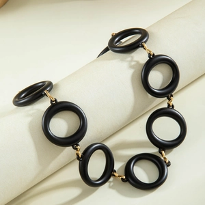 Detail of matte black acrylic links and gold metal connectors on chunky necklace
