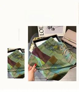 Gros plan détaillé d'un foulard en soie haut de gamme aux motifs vintage et tons vert émeraude