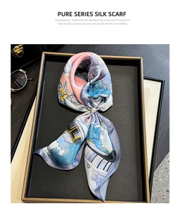 Detail of silk scarf with floral print and pearl buckle on a luxury display tray