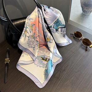 Detail of premium silk scarf with floral print tied to a leather bag for styling