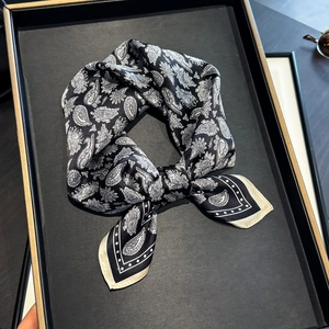 Klassisches Seidentuch für Damen mit Paisley-Muster elegant auf einem Tablett drapiert