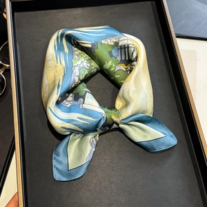 Elegant silk scarf with landscape art print on dark display tray for women's fashion