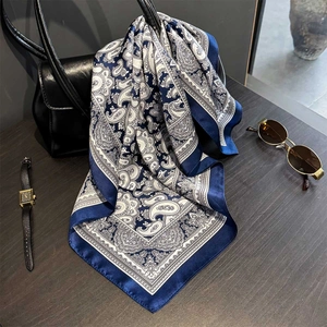 Foulard en soie avec imprimé cachemire et bordure marine sur un sac à main noir
