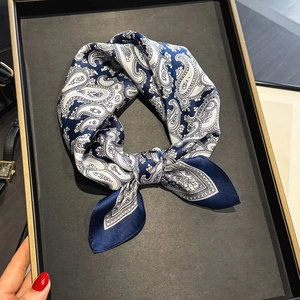 Foulard en soie à motif cachemire bleu marine sur un plateau de présentation noir