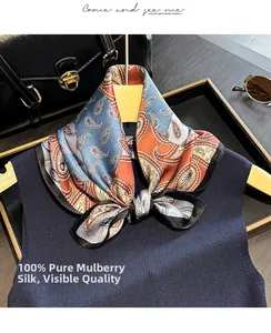 Detail of 100% mulberry silk scarf featuring vintage paisley patterns on blue sweater