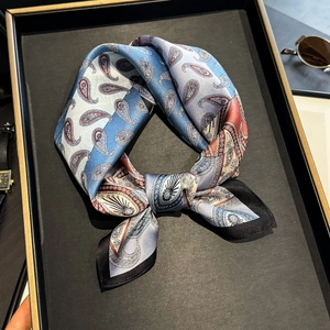 Elegant paisley mulberry silk scarf with blue and red pattern tied in a bow knot