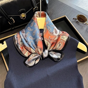 Elegant silk scarf with blue and orange paisley pattern tied as a bow for spring and summer