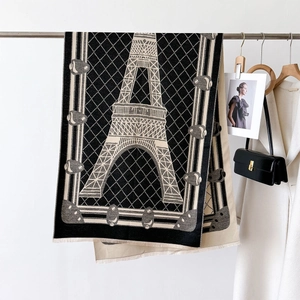 Detail of soft winter scarf featuring Eiffel Tower jacquard pattern and fringe edges