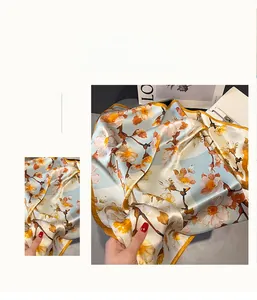 Close-up of elegant floral print silk scarf with luxury texture and glossy finish