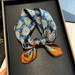 Navy blue mulberry silk square scarf with orange paisley print on a black tray