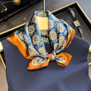 Elegant silk scarf with paisley pattern in teal and brown on navy knit top