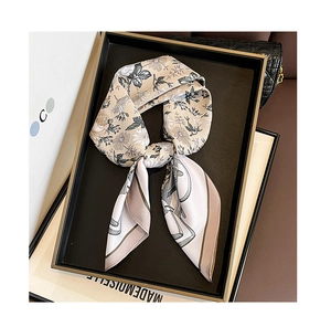 Detail of elegant twilly silk scarf with floral print on a luxury display tray