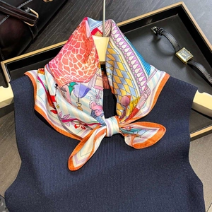 Silk neck scarf with colorful castle and giraffe print styled on a knit top and handbag