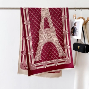 Detailed texture of thick cashmere shawl featuring Eiffel Tower pattern and soft tassels