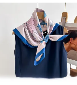 Close-up of pink and blue floral printed twill silk scarf tied on a navy top