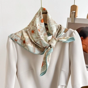 Élégant foulard en soie vert menthe avec motif marguerites vintage sur l'encolure d'une robe