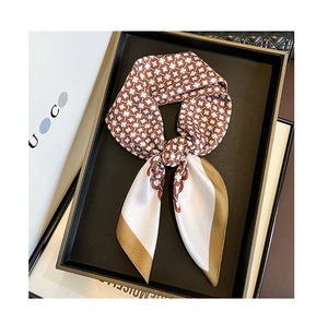 Detail of elegant orange and white geometric chain print silk scarf in gift packaging