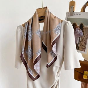 Élégant foulard en soie marron avec imprimé floral blanc sur cintre en bois avec robe
