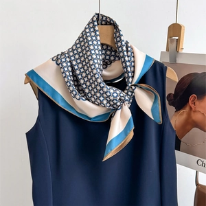 Premium twill silk scarf with geometric chain patterns tied on a sleeveless navy top