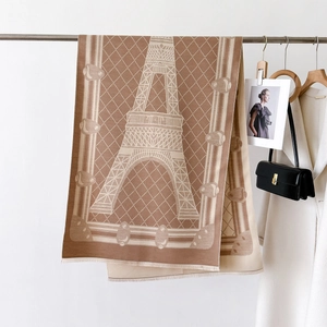 Detailed texture of jacquard scarf with Eiffel Tower pattern and soft fringe edges